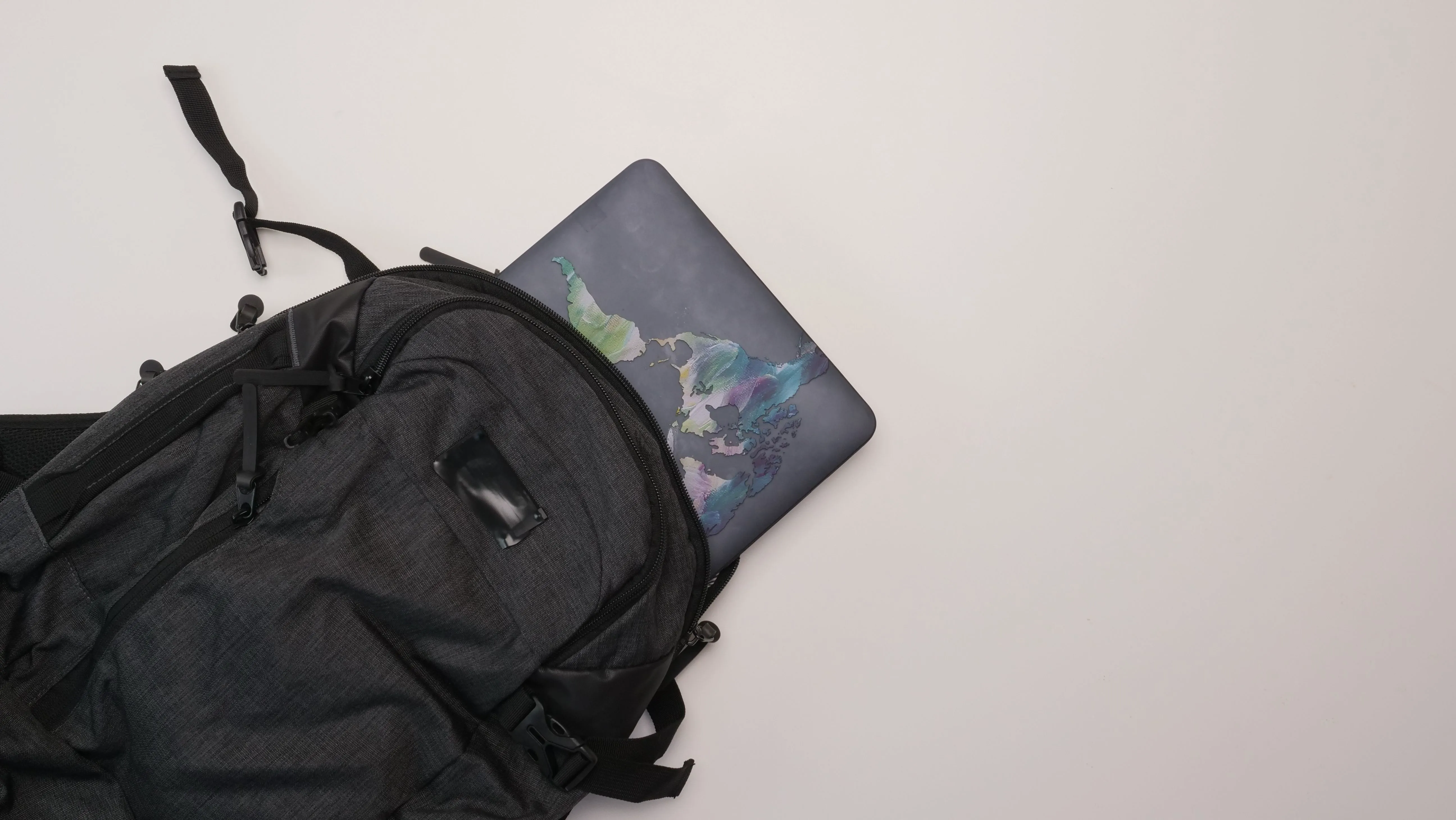 Mochila preta com notebook sobre fundo claro